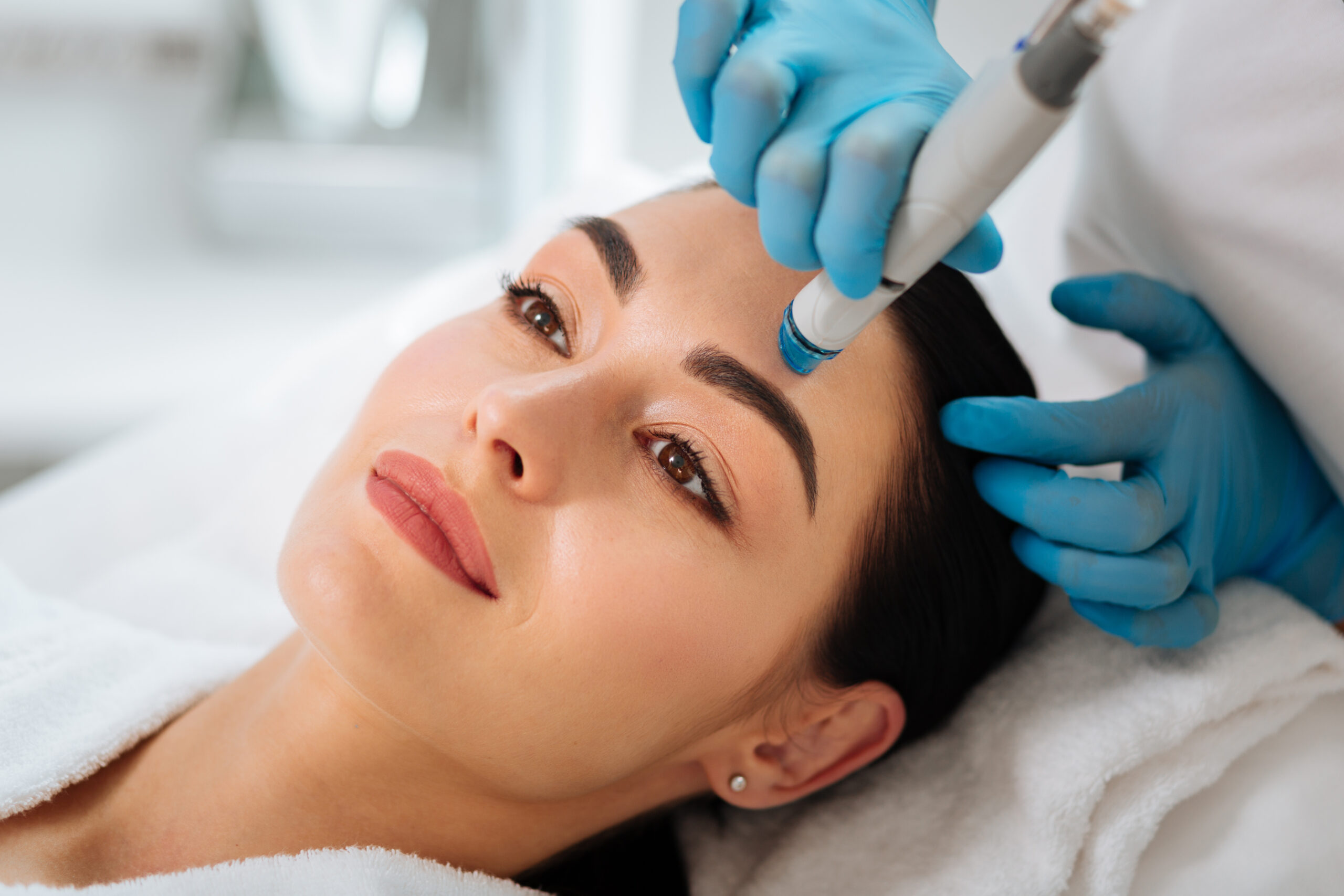 Perfect cleansing. Face of a beautiful pleasant woman being cleansed during hydrafacial procedure